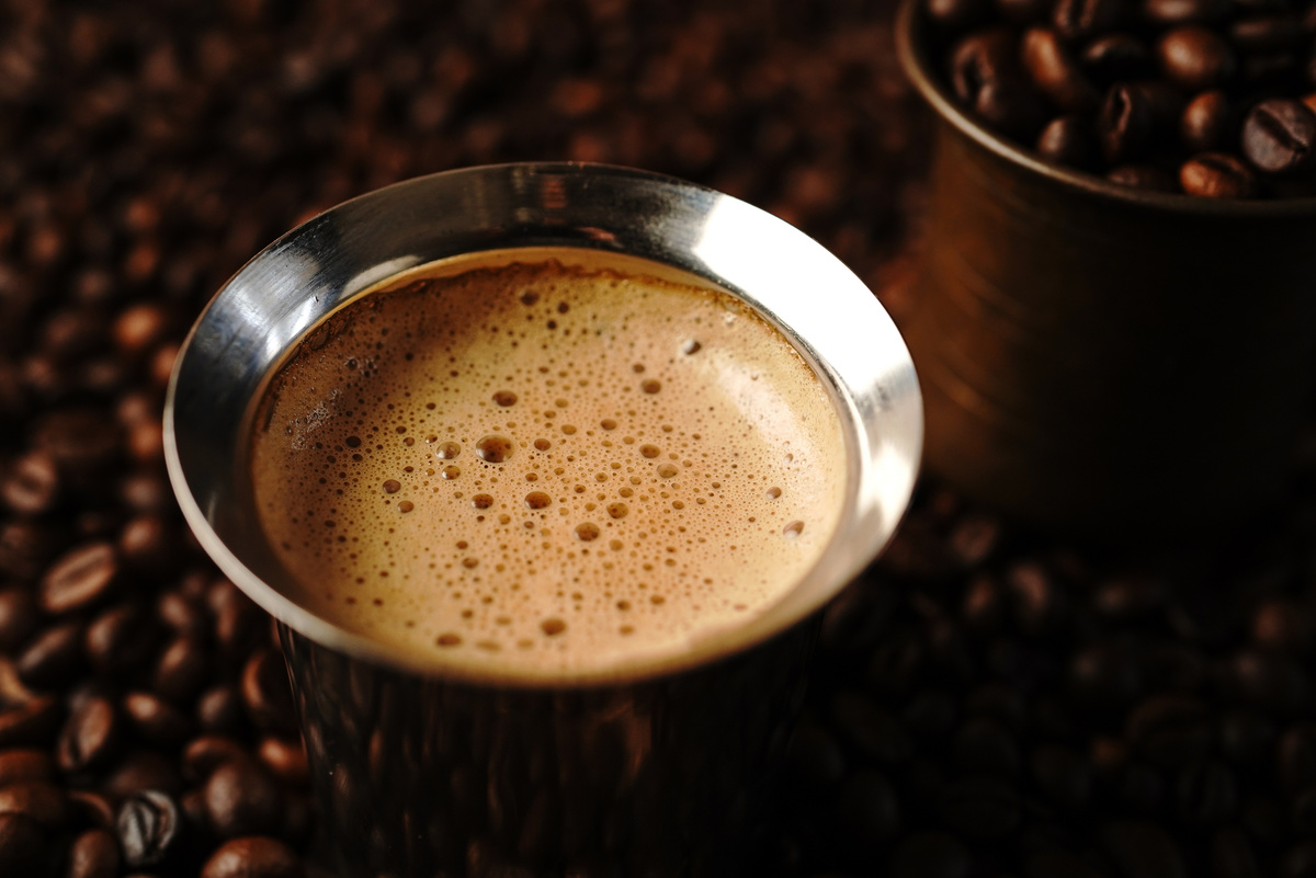 South Indian filter coffee served in steel cup and saucer, selective focus